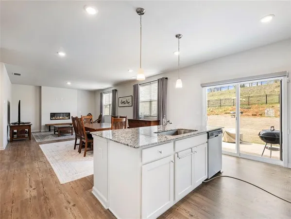 a large kitchen with lots of counter space a sink dining table and chairs