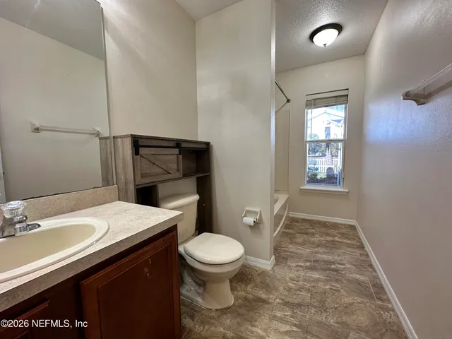 a bathroom with a sink a toilet a mirror and shower
