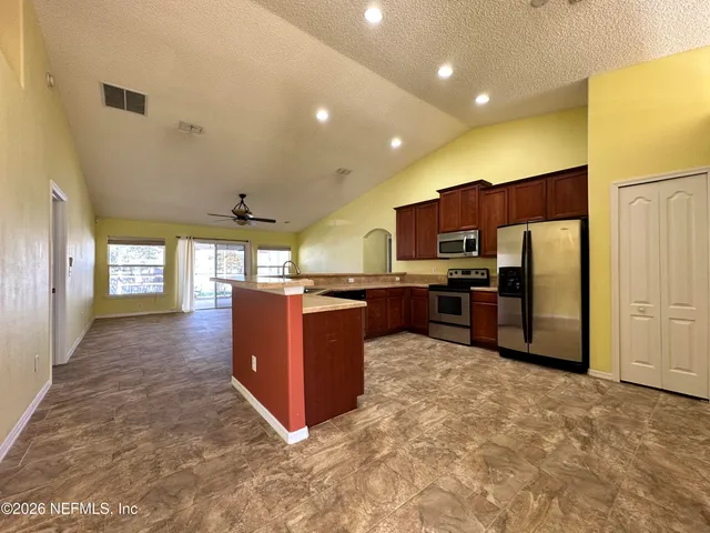 a kitchen with granite countertop a refrigerator and a sink