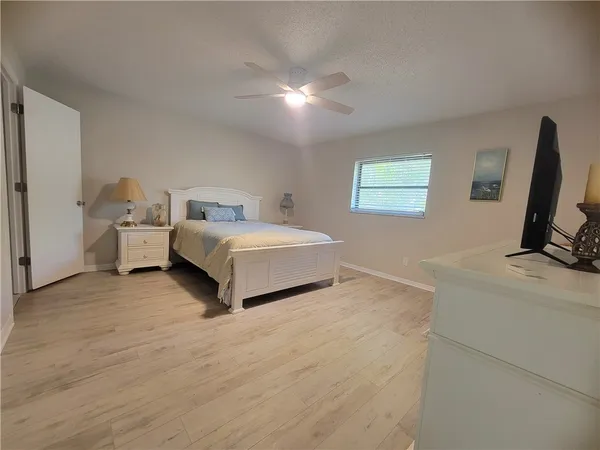 a spacious bedroom with a bed and a flat screen tv