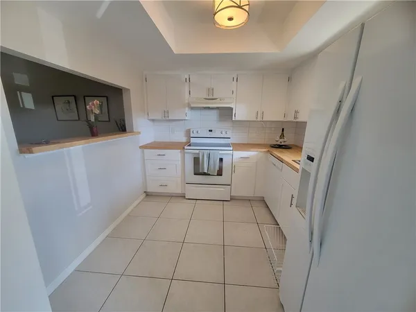 a kitchen with a sink a stove a refrigerator and cabinets