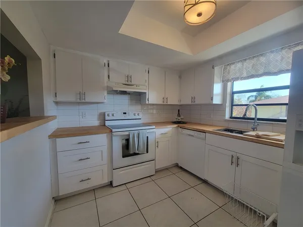 a kitchen with cabinets appliances and a window