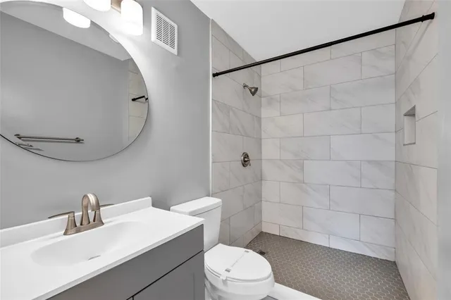 a bathroom with a sink a toilet and shower