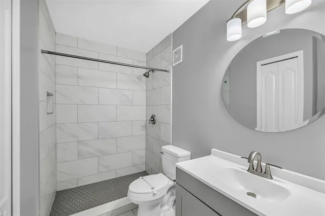 a bathroom with a sink a toilet and shower