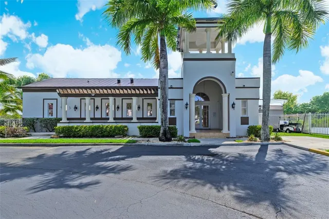 a view of a brick house with a yard and palm trees