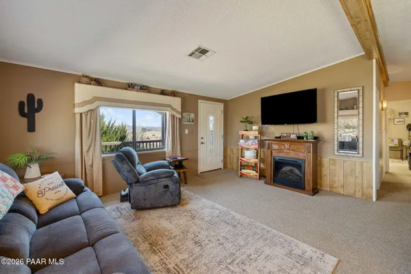 a living room with furniture a fireplace and a flat screen tv