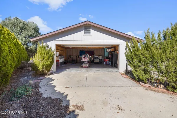a view of a house with large trees and plants