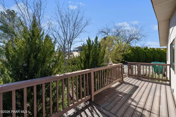 a view of balcony with wooden floor and fence