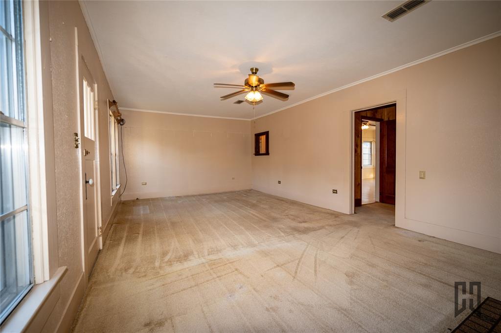 3209 Highway 2 Alternate Haynesville, LA 71038 - Photo 6 of 15 an empty room with chandelier fan and windows