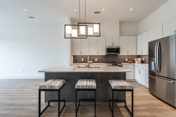 a kitchen with stainless steel appliances a sink a stove a refrigerator and cabinets