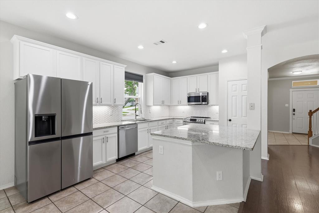 13236 Ridgepointe Road Fort Worth, TX 76244 - Photo 6 of 19 a kitchen with stainless steel appliances granite countertop a refrigerator and a stove top oven