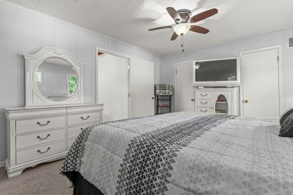263 Crestwood Loop Avinger, TX 75630 - Photo 20 of 40 a bedroom with a bed a flat screen tv and a dresser