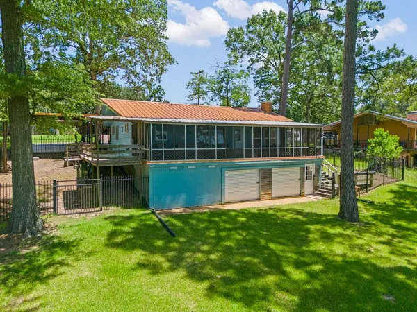 a view of a house with a yard and a large tree