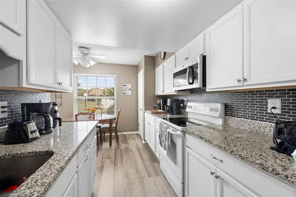 a kitchen with stainless steel appliances granite countertop a stove a sink dishwasher and microwave oven with cabinets