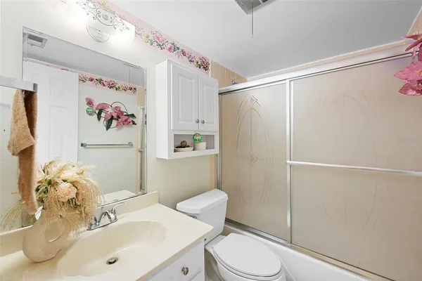 a bathroom with a sink mirror vanity and toilet