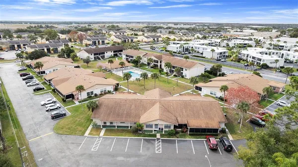 an aerial view of residential houses with outdoor space and parking