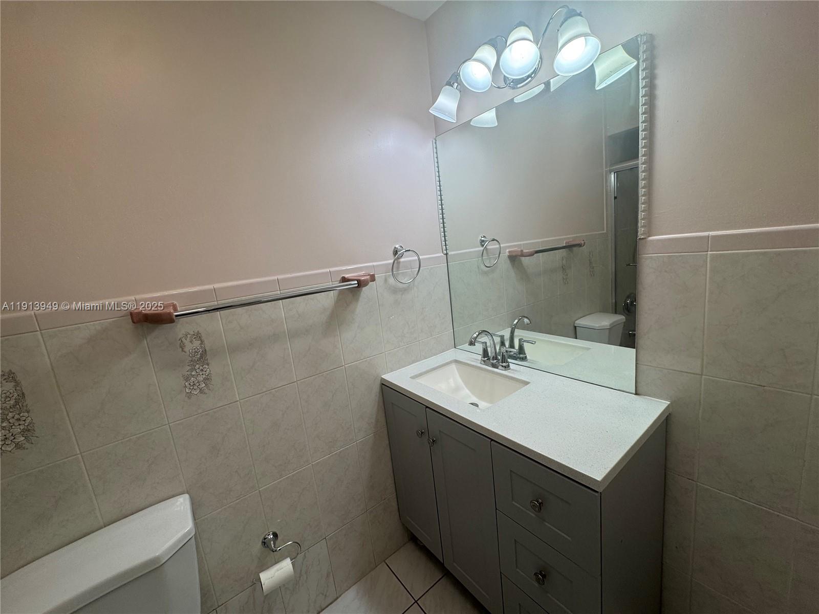 29523 Southwest 144th Court Homestead, FL 33033 - Photo 29 of 59 a bathroom with a sink a light fixture and a toilet