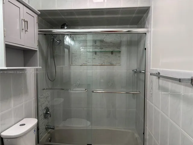 a bathroom with a shower a toilet and a sink
