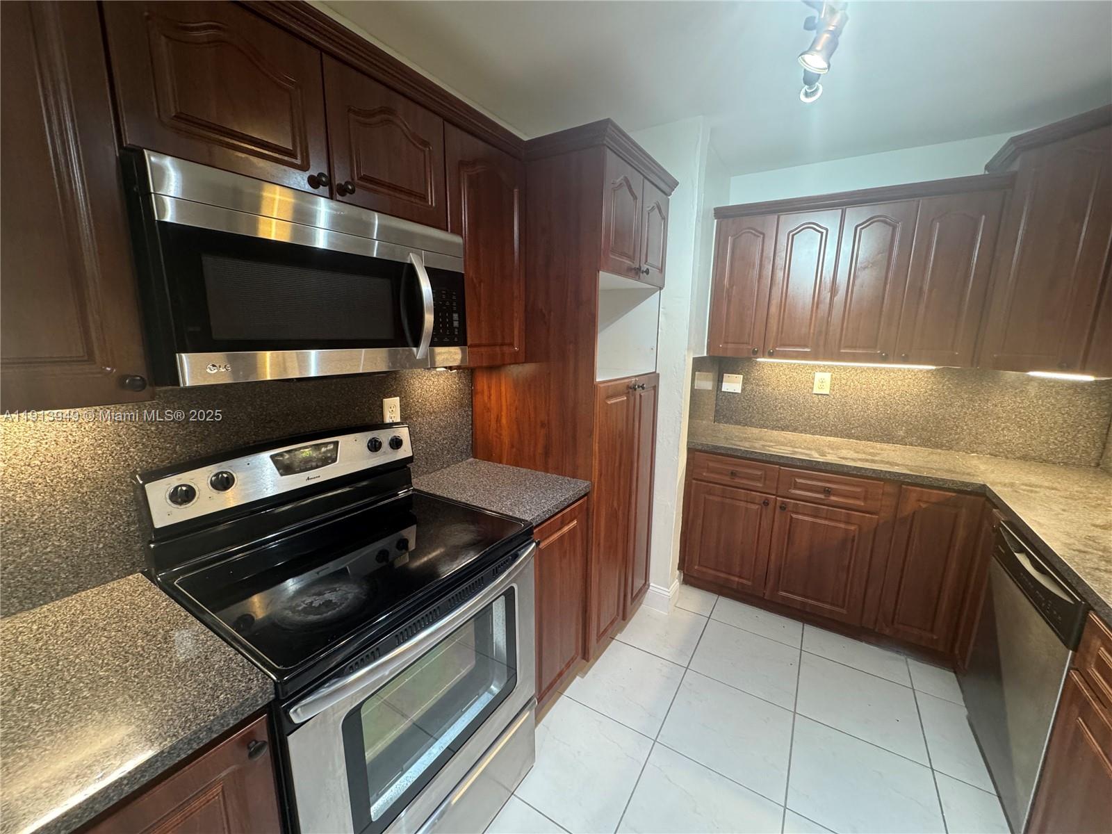 29523 Southwest 144th Court Homestead, FL 33033 - Photo 8 of 59 a kitchen with a stove microwave and sink