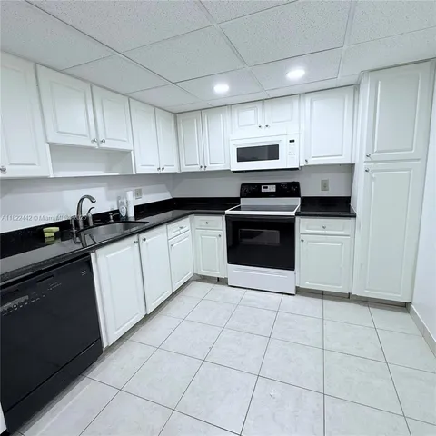 a kitchen with cabinets stainless steel appliances and a sink