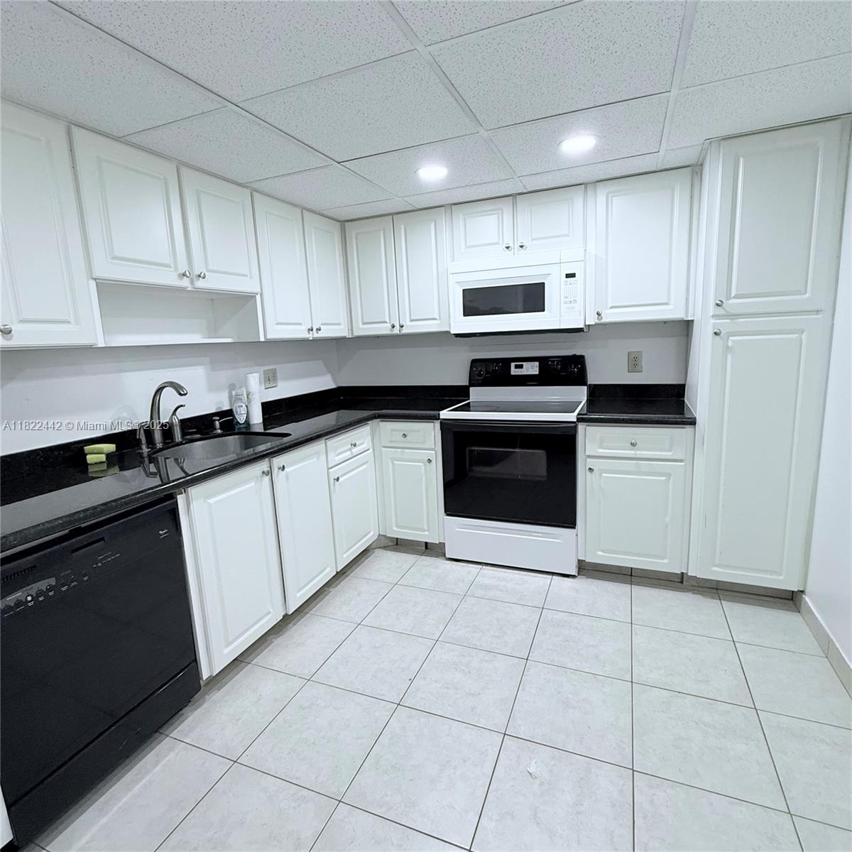 3980 Oaks Clubhouse Drive, Unit 302 Pompano Beach, FL 33069 - Photo 3 of 15 a kitchen with cabinets stainless steel appliances and a sink