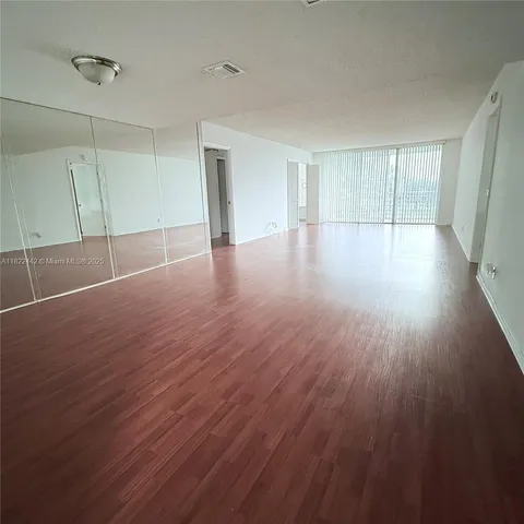 a view of a room with wooden floor and window