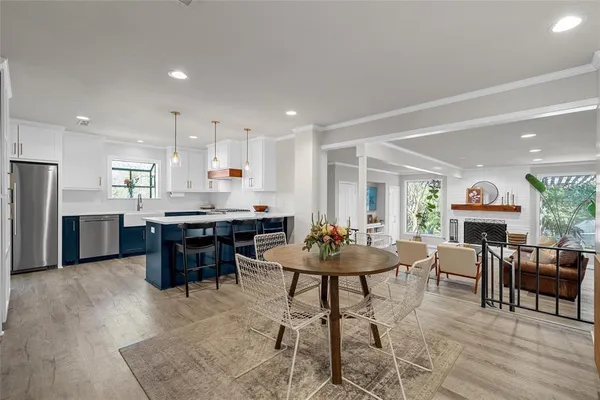 a living room with stainless steel appliances kitchen island furniture and a wooden floor