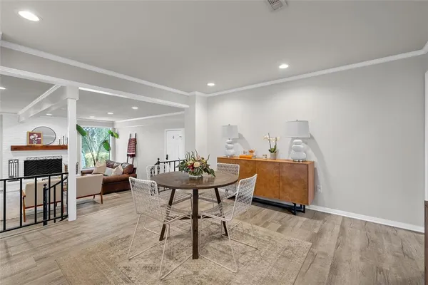 a living room with furniture a fireplace and a dining table with wooden floor