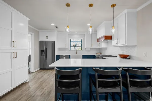 a kitchen with refrigerator and wooden floor