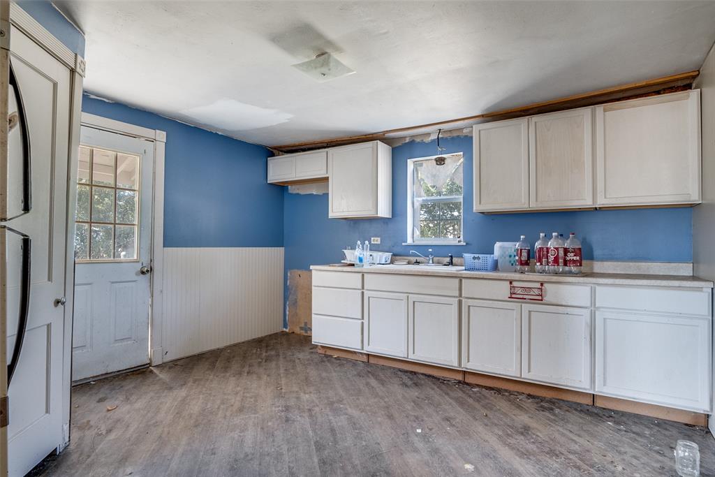 7165 County Road 1232 Godley, TX 76044 - Photo 4 of 17 a kitchen with granite countertop white cabinets and white appliances