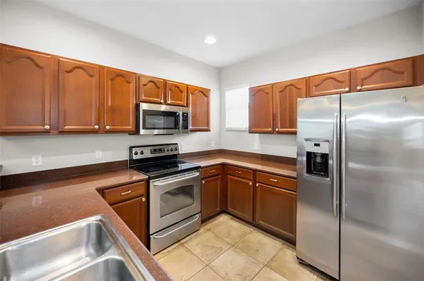 a kitchen with stainless steel appliances granite countertop a refrigerator and a sink