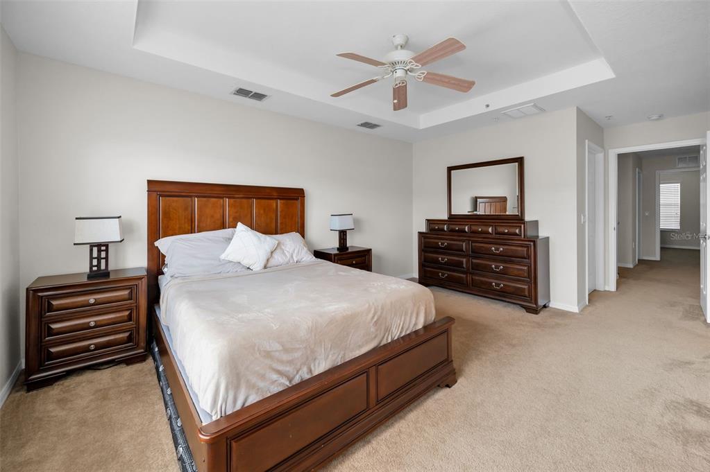 5628 Sea Turtle Court New Port Richey, FL 34652 - Photo 23 of 99 a spacious bedroom with a bed and a chandelier