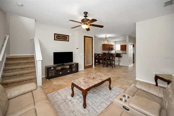 a kitchen with stainless steel appliances granite countertop a stove a refrigerator a sink a dining table and chairs with wooden floor