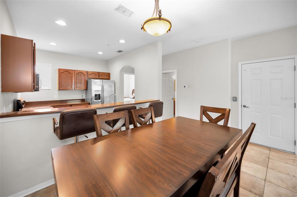 5628 Sea Turtle Court New Port Richey, FL 34652 - Photo 9 of 99 a kitchen with stainless steel appliances granite countertop a stove a refrigerator a sink a dining table and chairs with wooden floor
