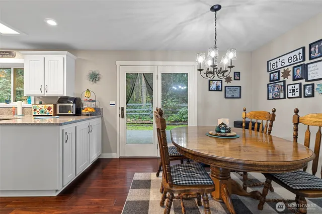 a view of a dining room with furniture a chandelier and wooden floor
