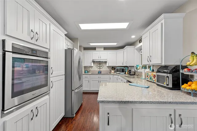 a kitchen with granite countertop stainless steel appliances and wooden cabinets