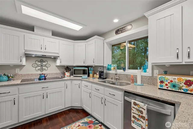 a kitchen with white cabinets sink and window