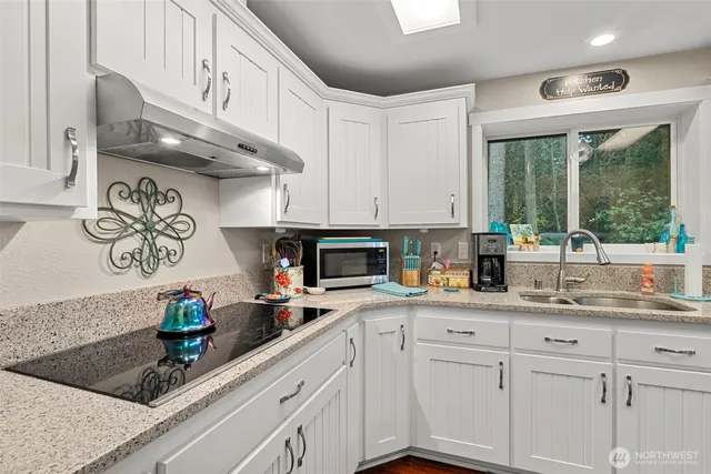a kitchen with stainless steel appliances granite countertop a sink a stove and cabinets