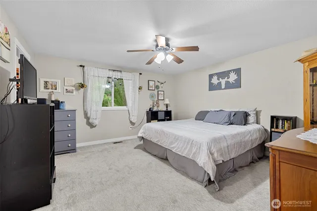 a spacious bedroom with a bed and a chandelier