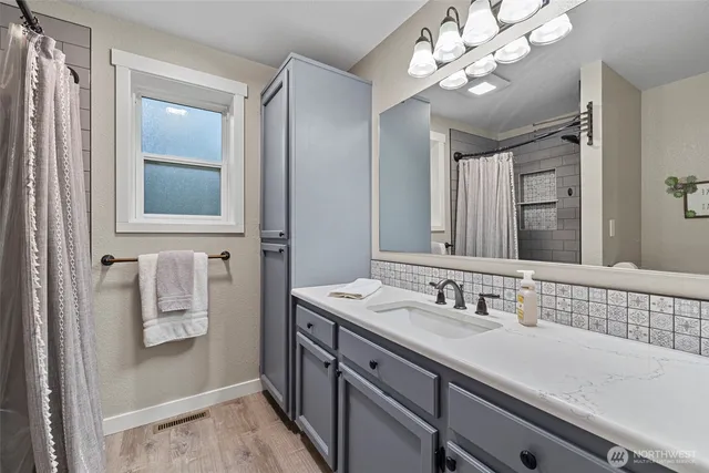 a bathroom with a sink a mirror and a shower