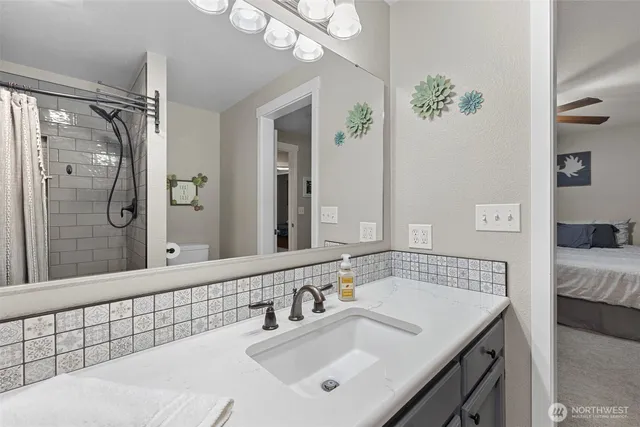 a bathroom with a sink vanity granite tub and shower