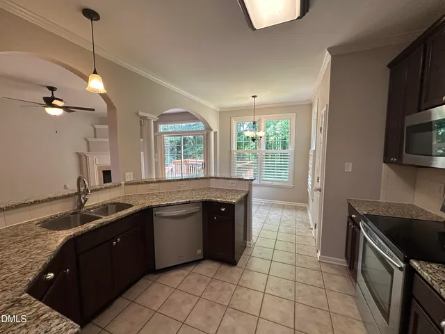a kitchen with a sink a counter top space appliances and cabinets