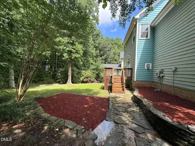 a view of a backyard with lawn chairs