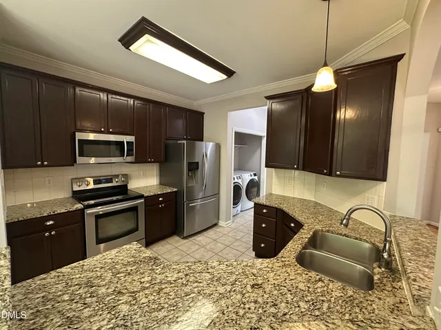 a kitchen with stainless steel appliances granite countertop a sink refrigerator and microwave