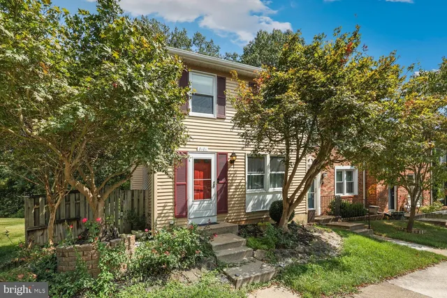 a front view of a house with a tree