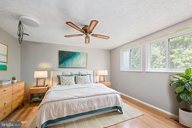 a bedroom with a bed and a potted plant on the dresser