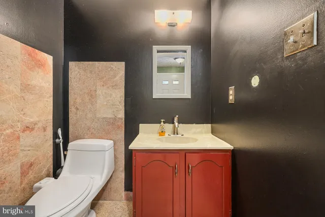 a bathroom with a toilet a sink and mirror