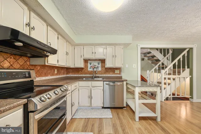 a kitchen with a stove a sink and a microwave