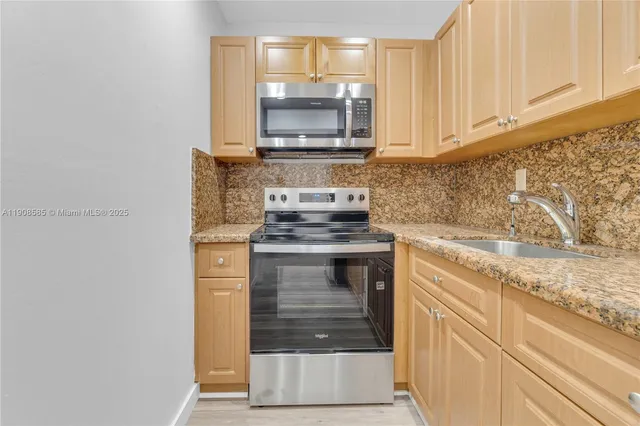 a kitchen with granite countertop a stove and a sink