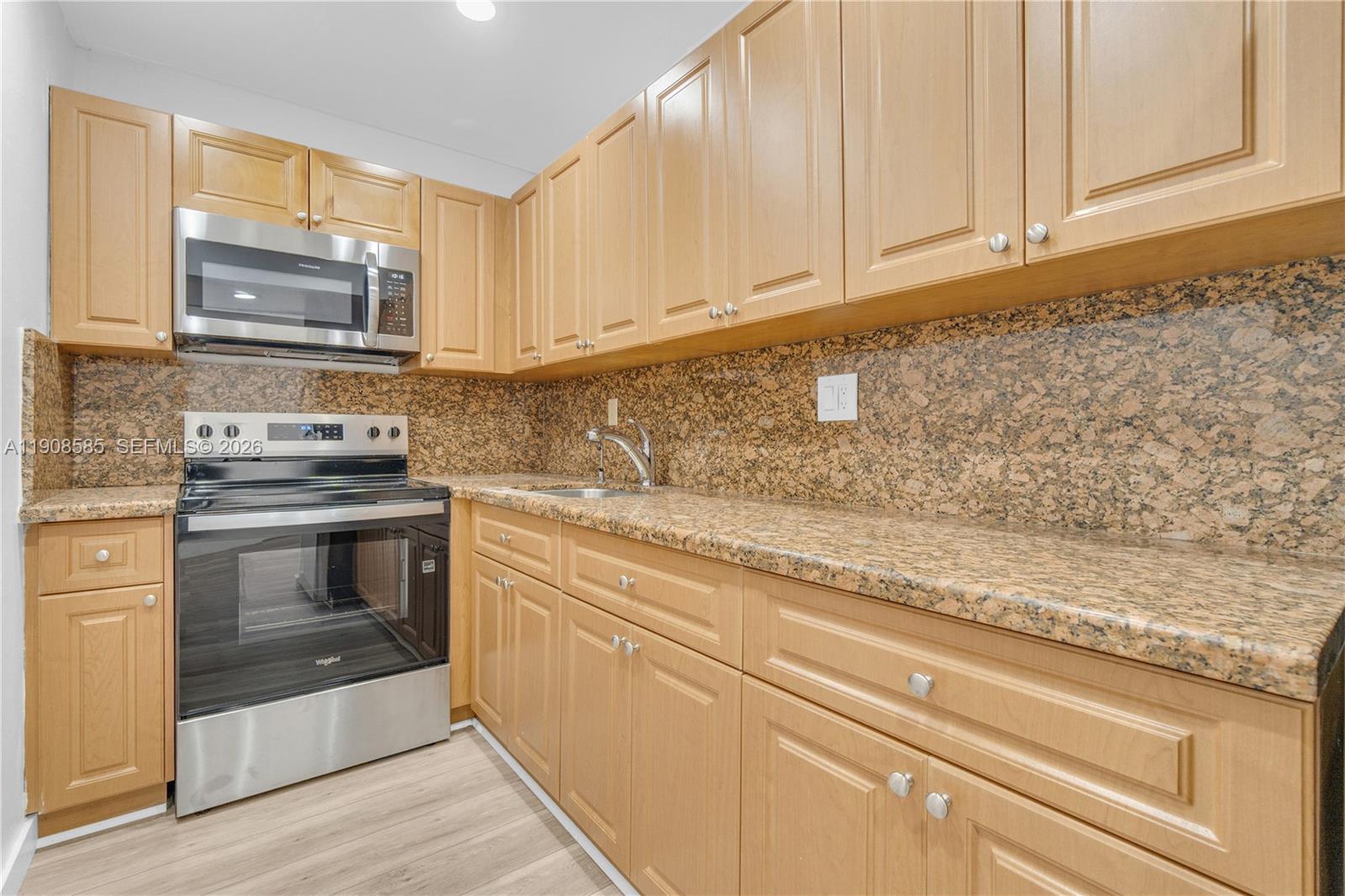 4709 Northwest 7th Street, Unit 2049 Miami, FL 33126 - Photo 19 of 51 a kitchen with granite countertop cabinets stainless steel appliances and a counter space